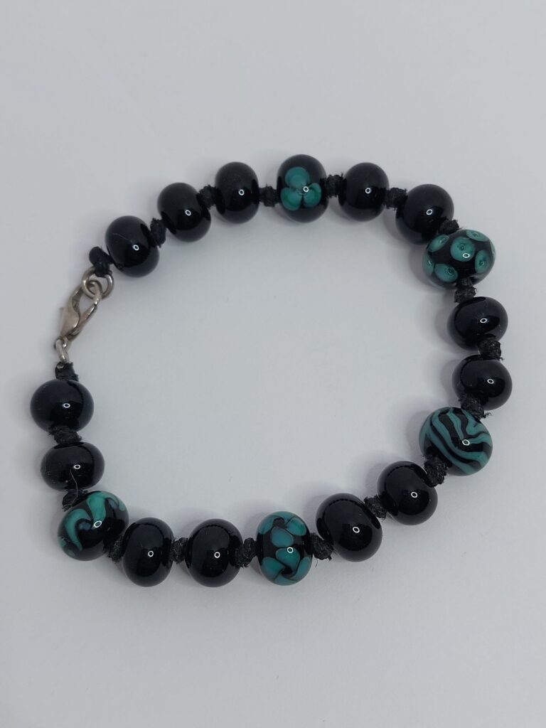 Armband zwart met zeegroene accenten. 
