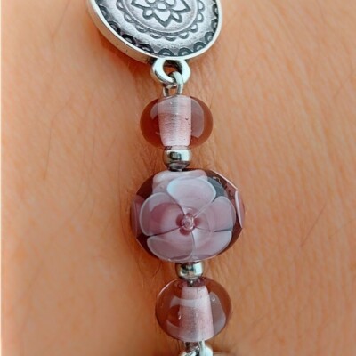 uitvergroting model paars-roze armband met handgemaakte glaskralen met bloemmotief