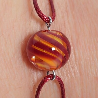 uitvergroting model kleurrijke armband met handgemaakte rode/gele/oranje glaskralen